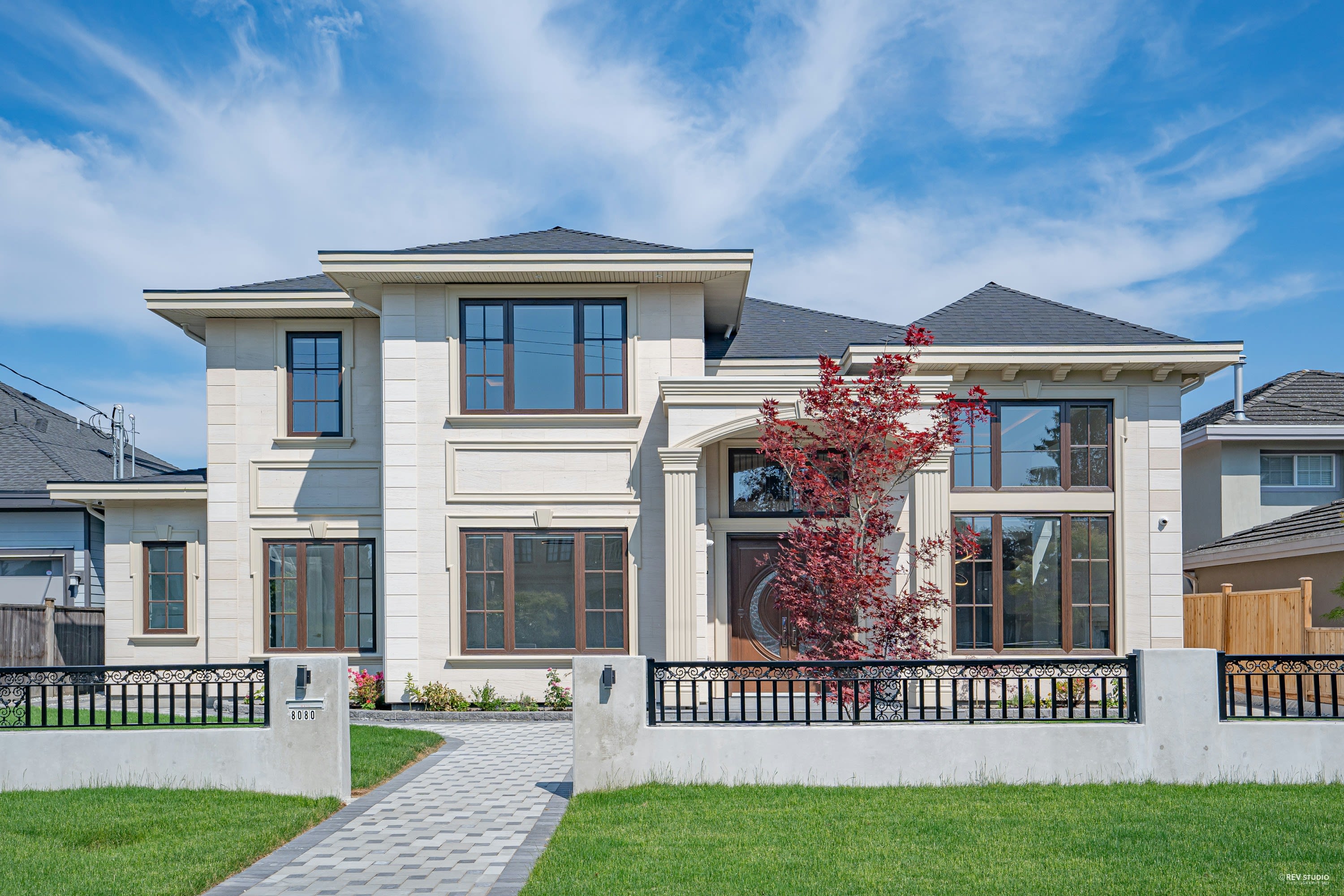 Custom luxury home exterior at 8080 Alanmore Place featuring modern traditional architecture, large windows, landscaped front