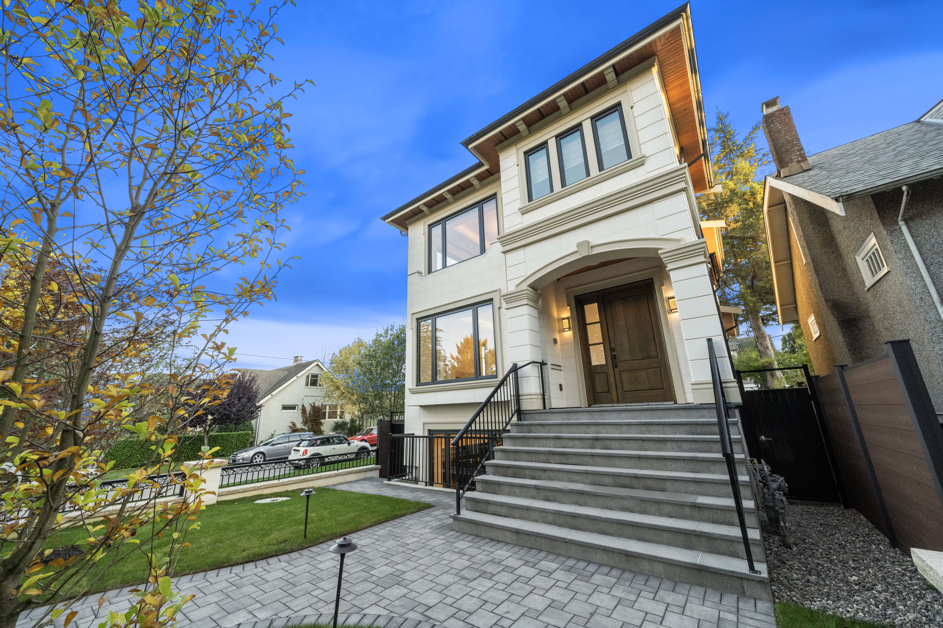 Custom home exterior at 3802 West 22nd Avenue featuring timeless architecture, large black-framed windows, stone entry steps