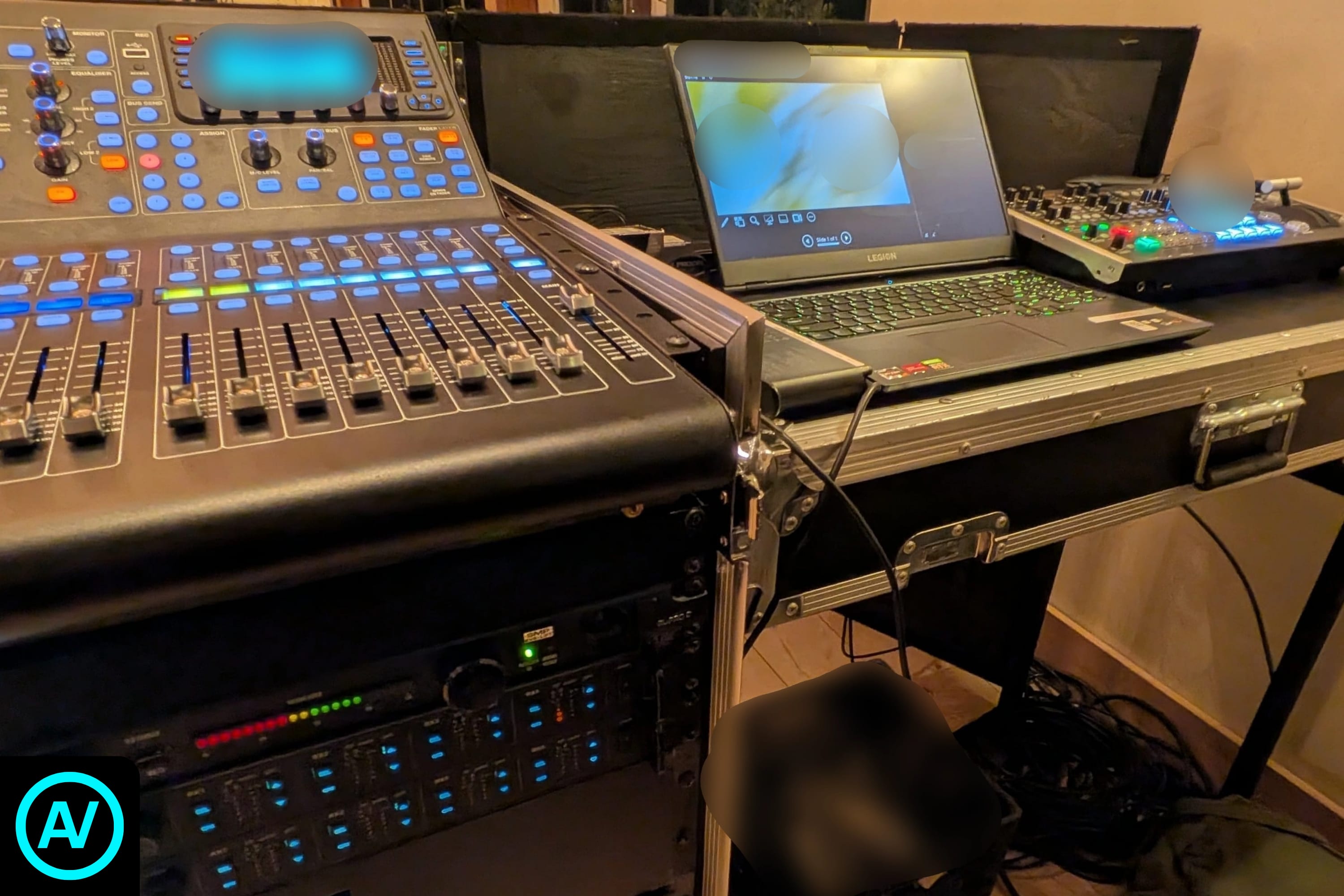 Live event control station with digital audio consoles, production laptop, and equipment racks