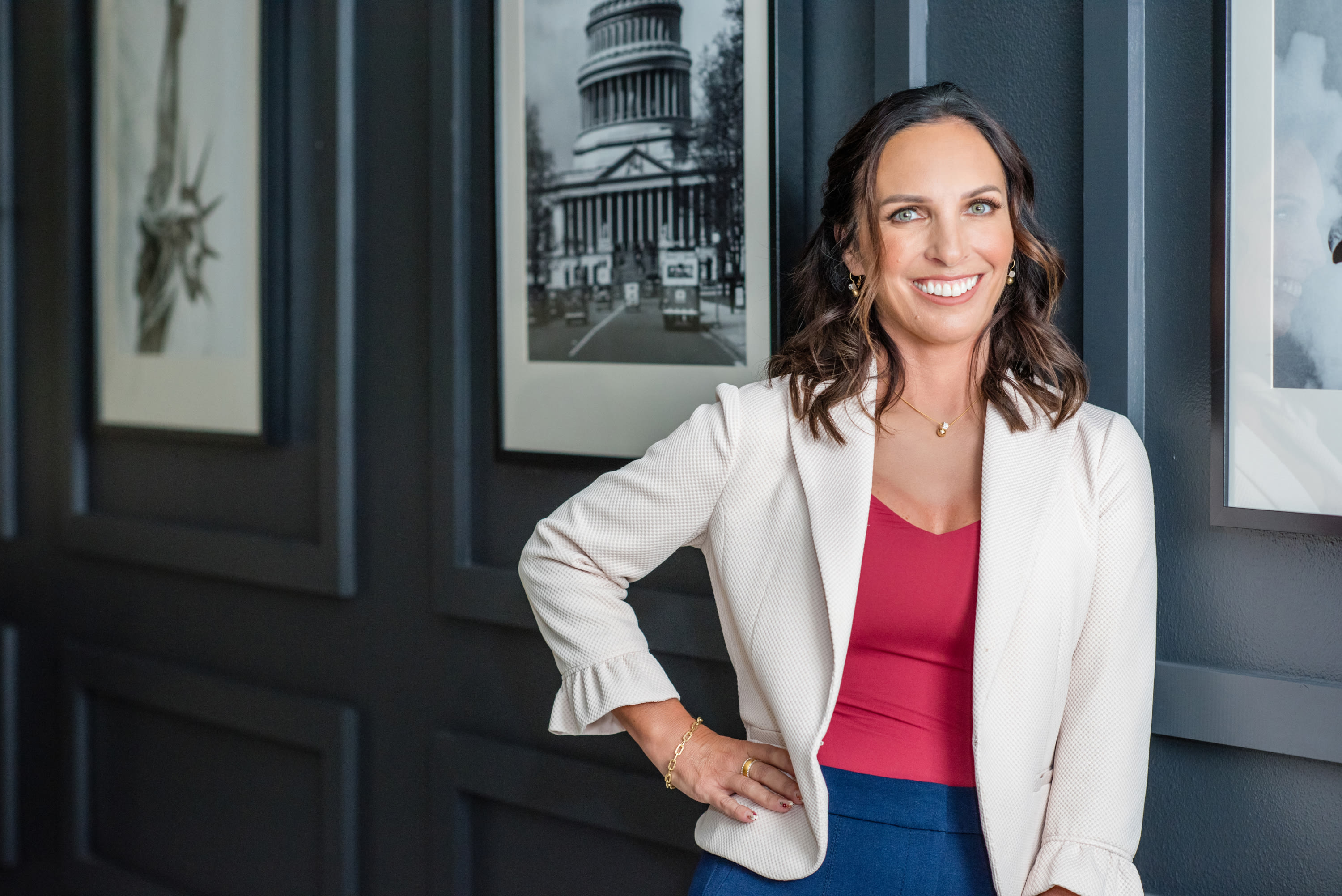 Nancyrose Hernandez, California employment law attorney, standing confidently in her Murrieta office with framed black and wh