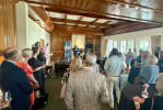 A room full of people listening to a speaker