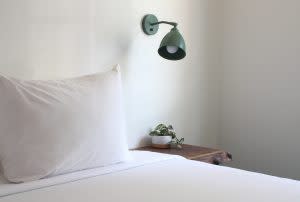 clean white pillow, minimalistic style with a modern lamp and small plant