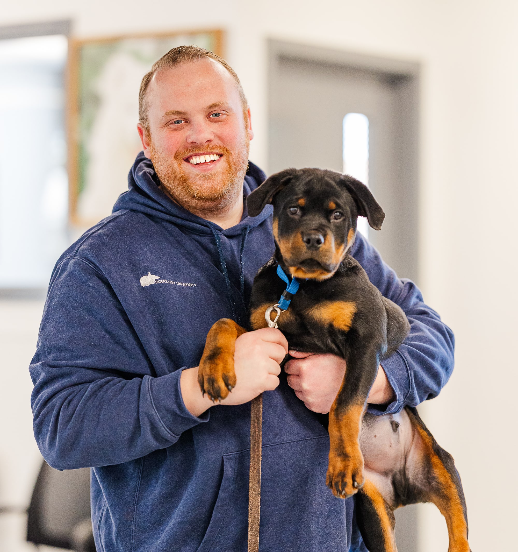 Matthew Lamarand of Dogology University holding a puppy during a calm, hands-on dog training session in West Michigan.