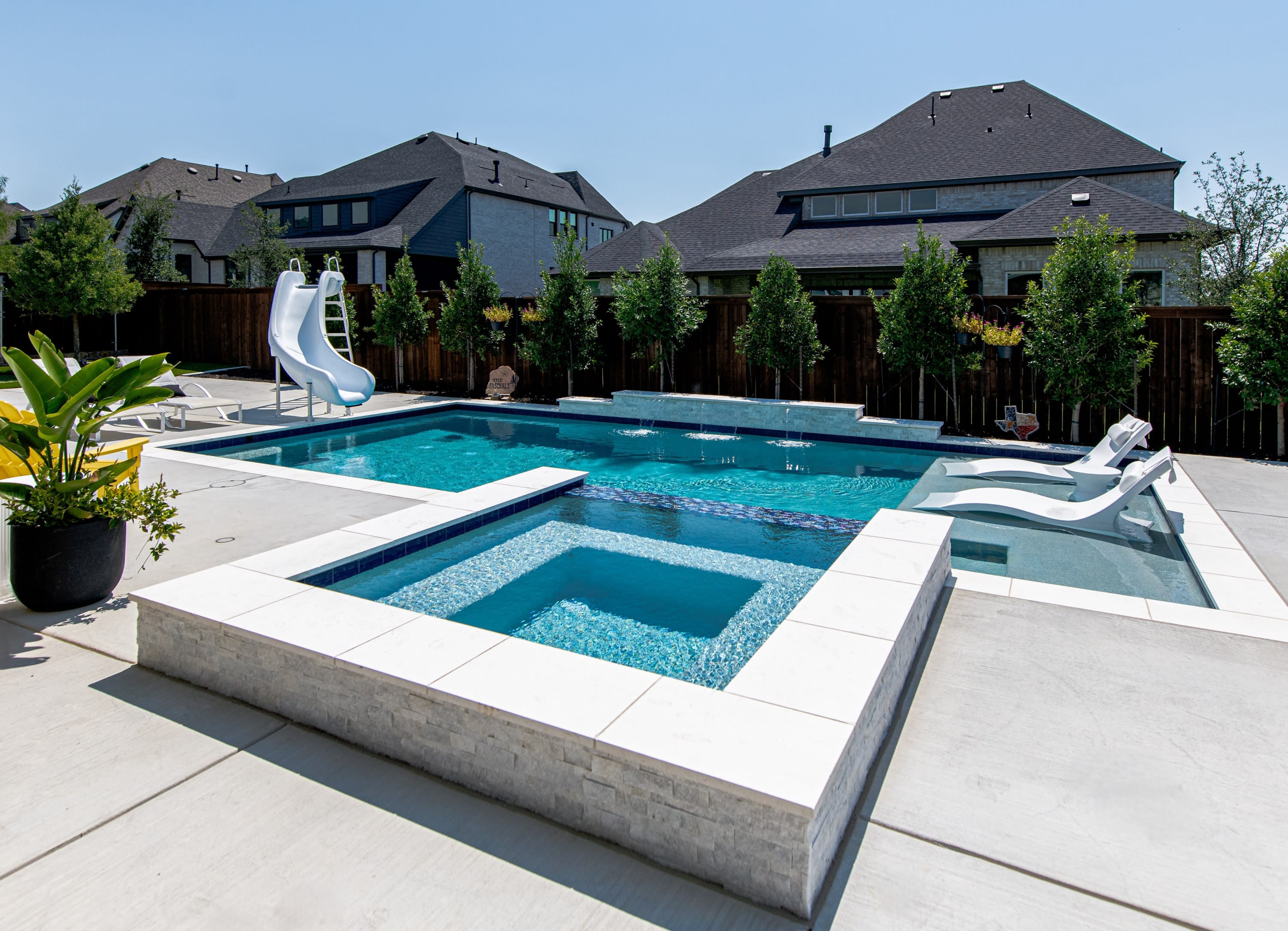 Luxury family pool with spa and waterslide by Canyon Oak Pools in Celina, TX