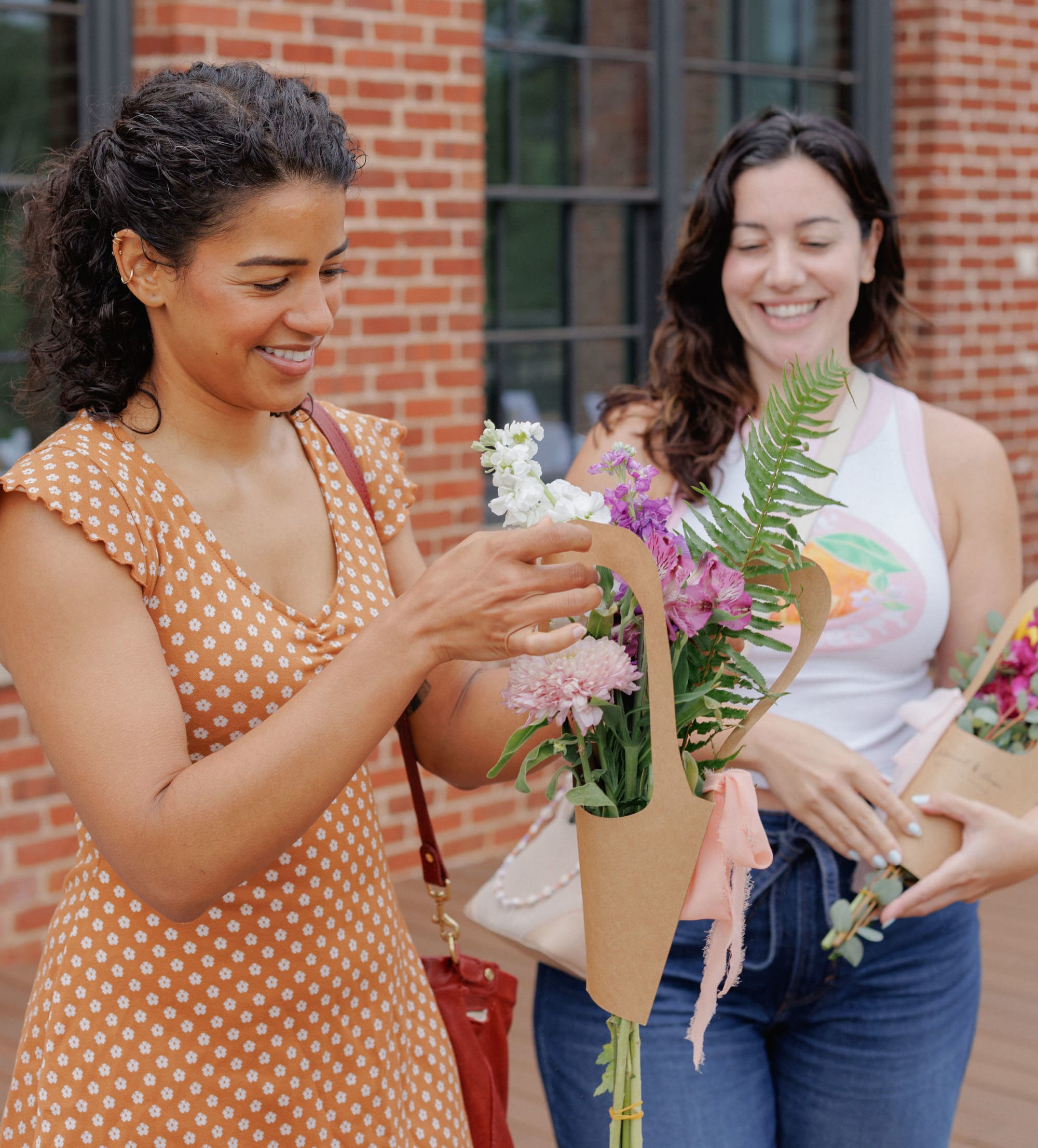 two women making bouquet of flowers