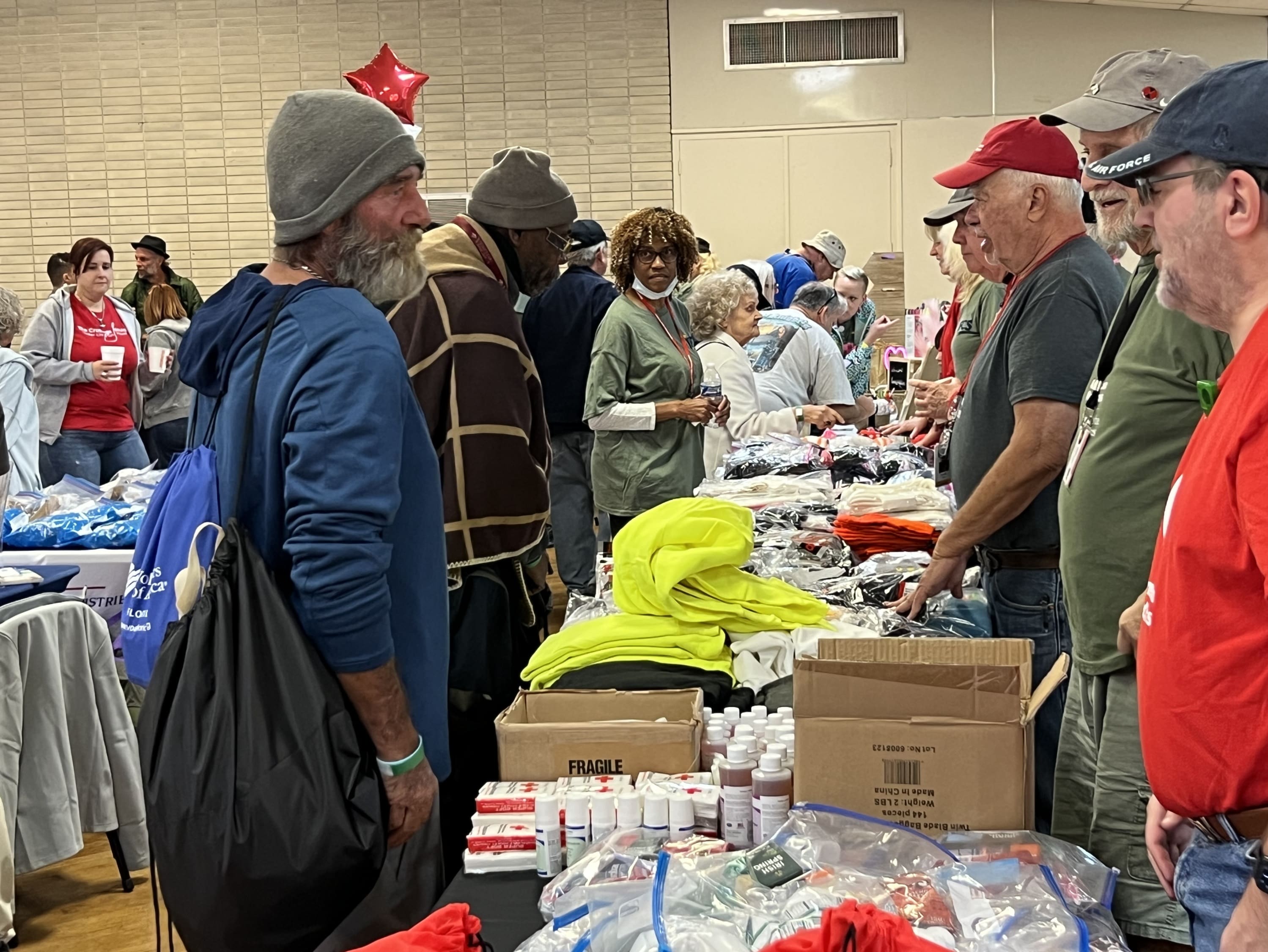 Homeless veterans stand in line to receive care items