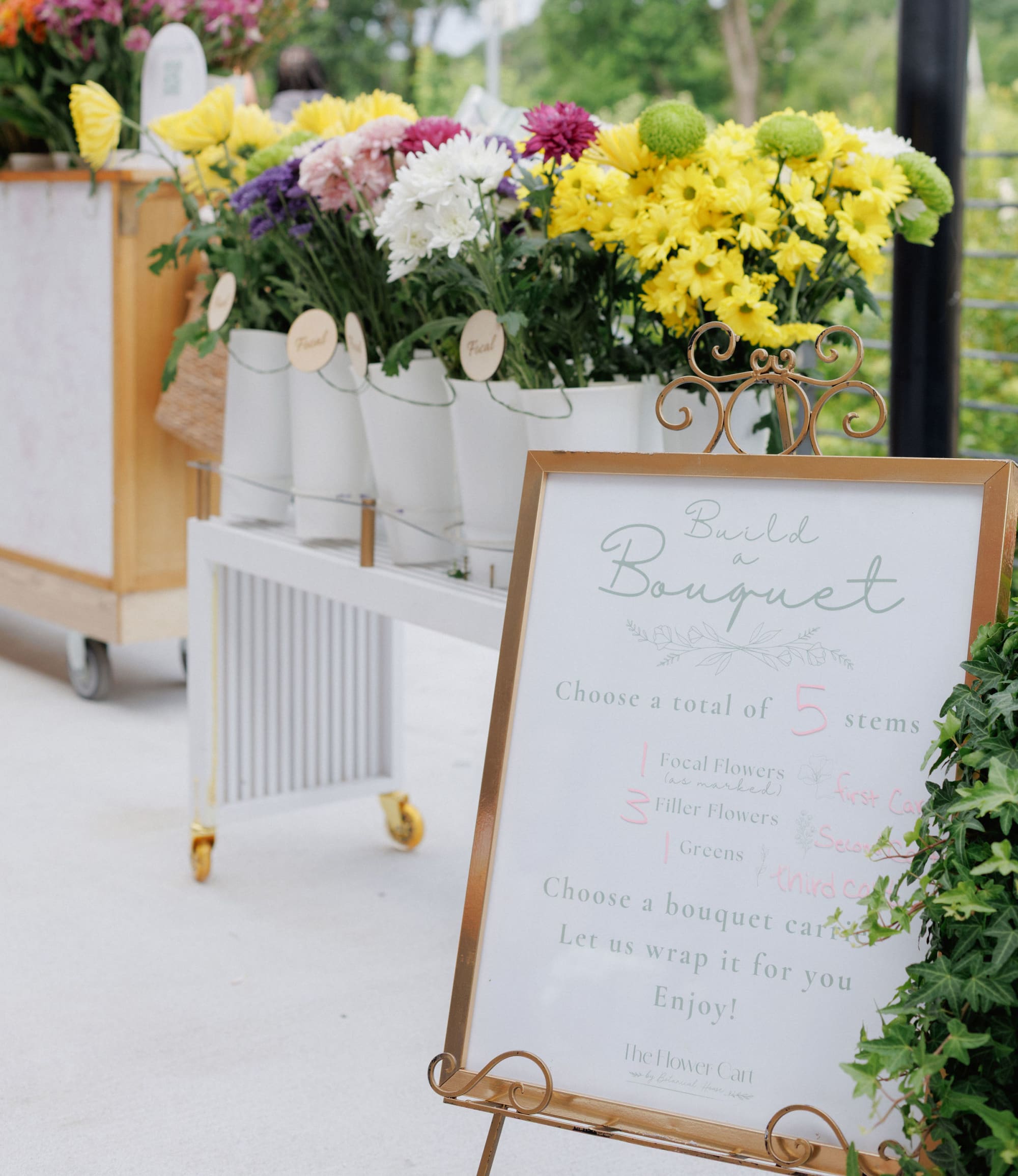 a flower cart with a sign on how to build a bouquet