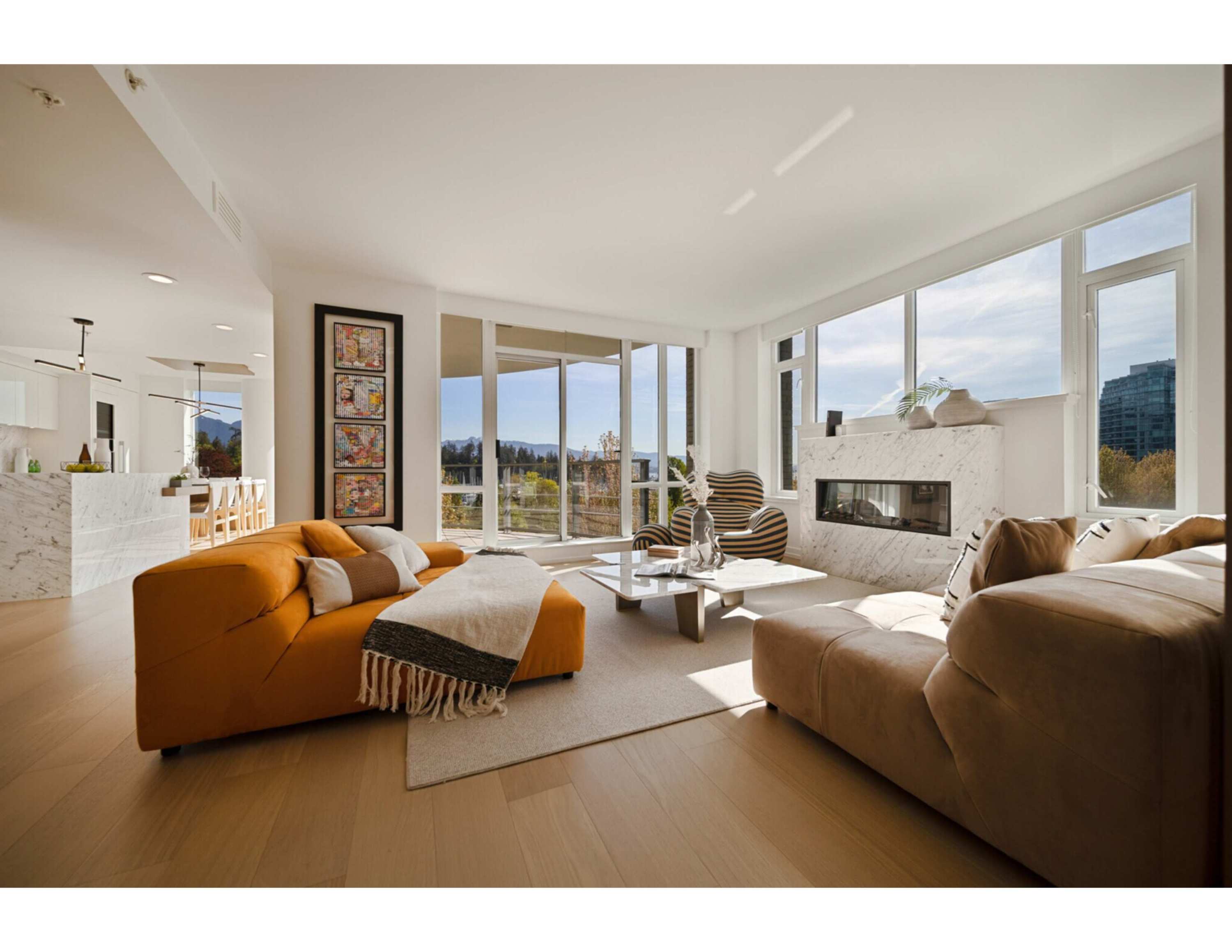 Bright apartment living room with a marble-pattern fireplace surround, light wood flooring, expansive windows and orange and