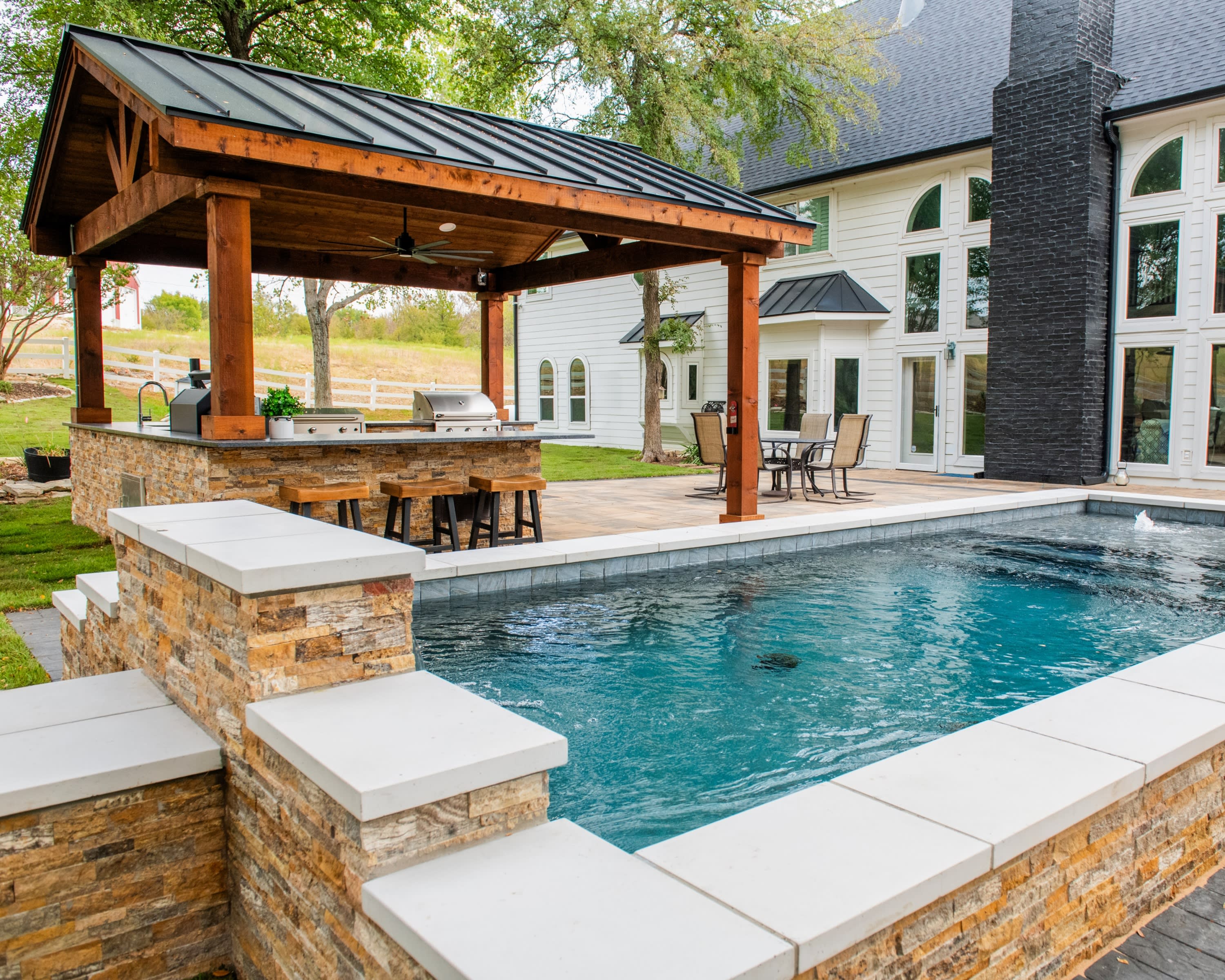 Luxury pool and outdoor kitchen by Canyon Oak Pools in Roanoke, TX