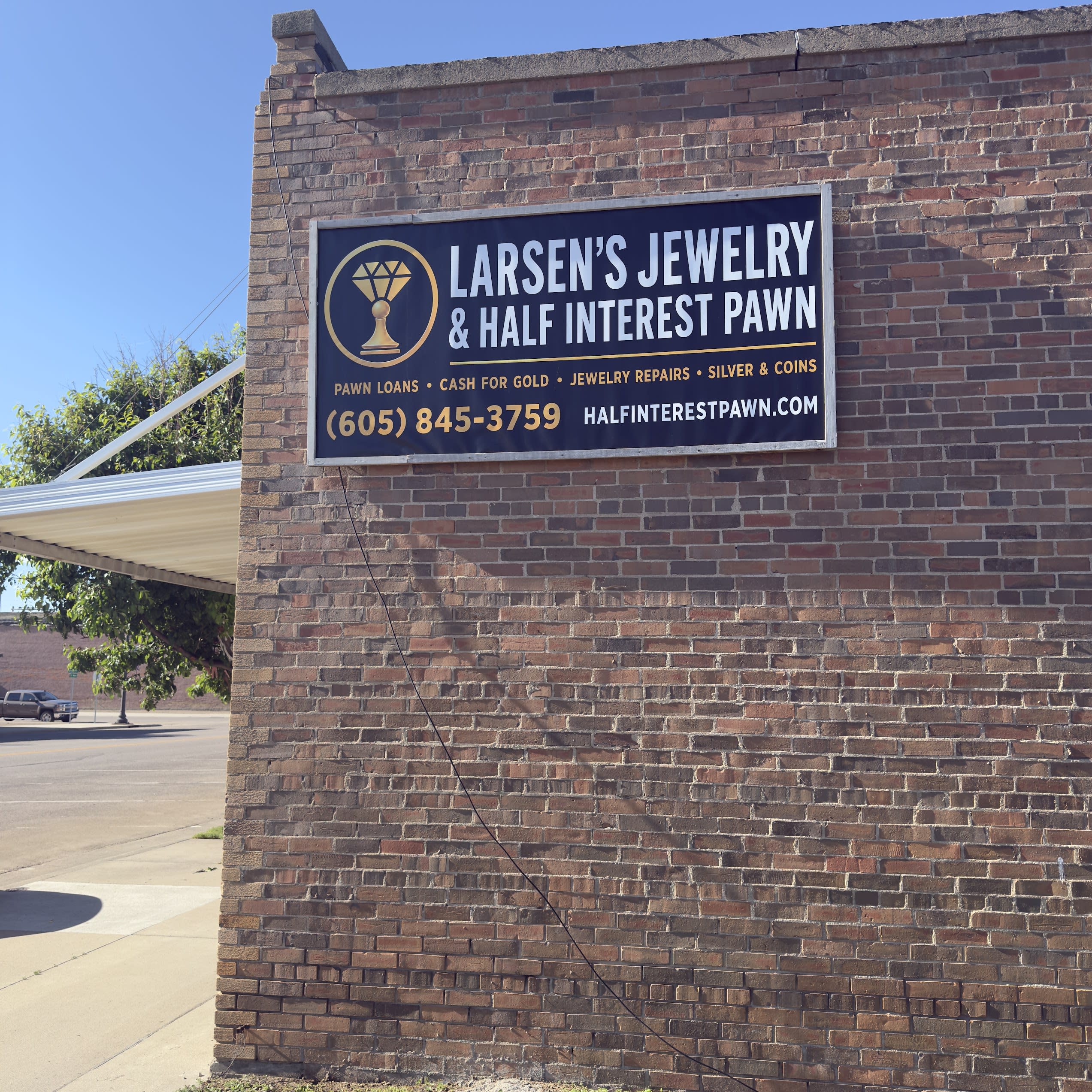 Larsen's Jewelry & Half Interest Pawn sign in Mobridge, SD — pawn loans, cash for gold, jewelry repairs, silver and coins.