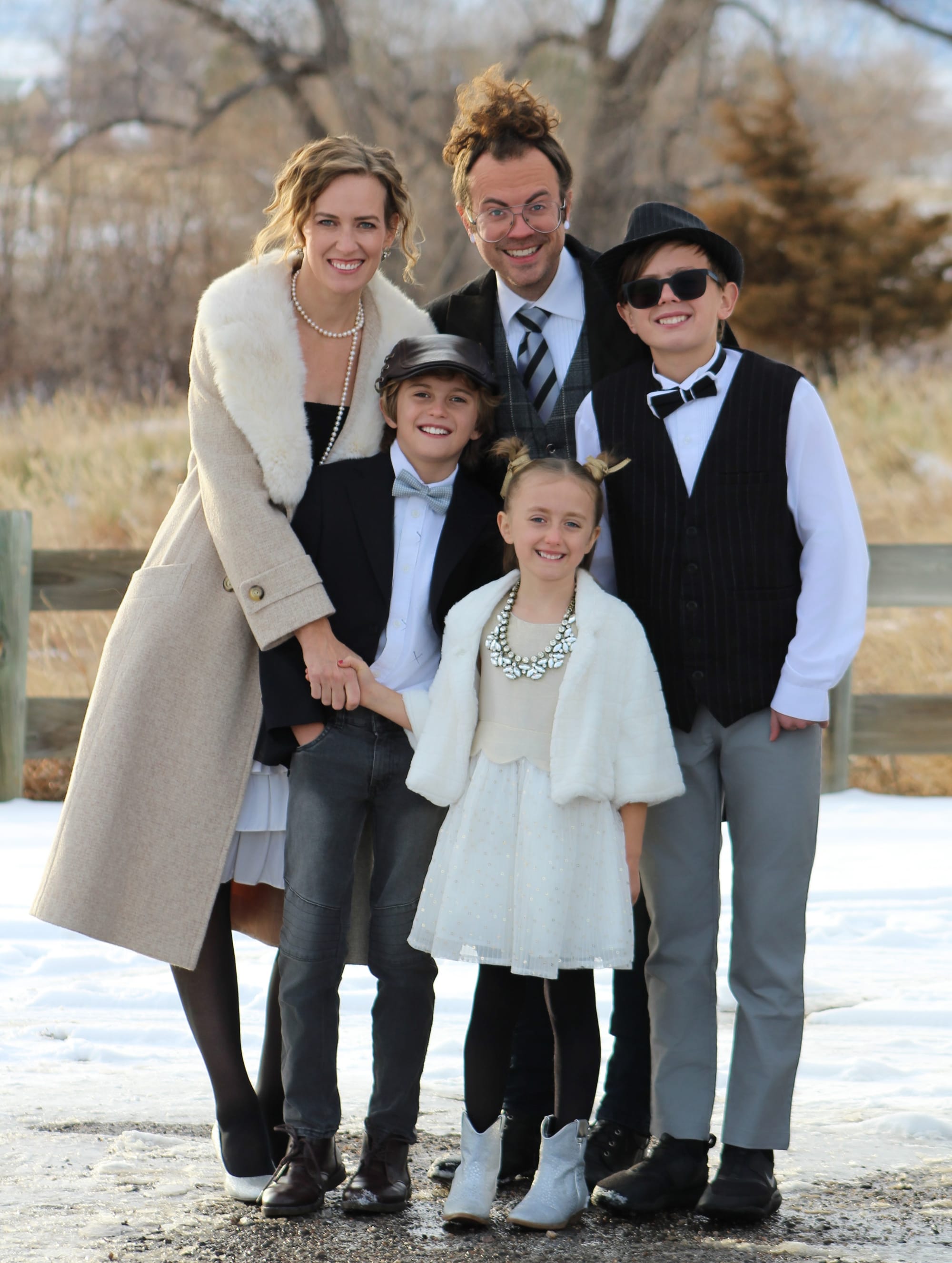 Mom and dad with two sons and a daughter dressed up for family portrait outside.