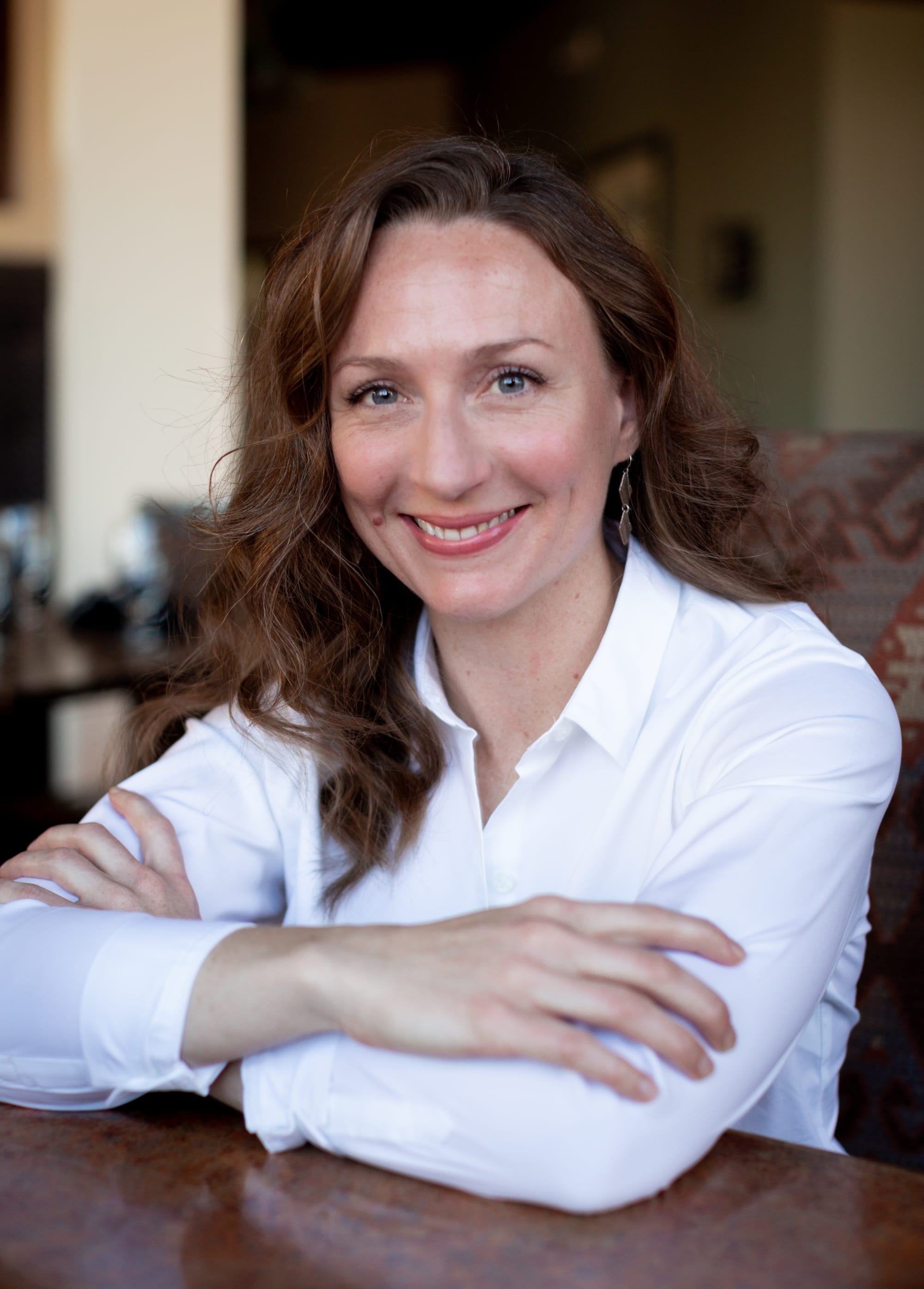 image of a woman in a white shirt sitting at a table
