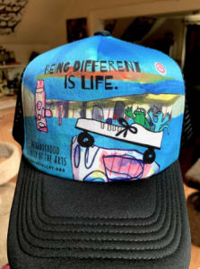 hat that has art on it that says, "Being Different is life"