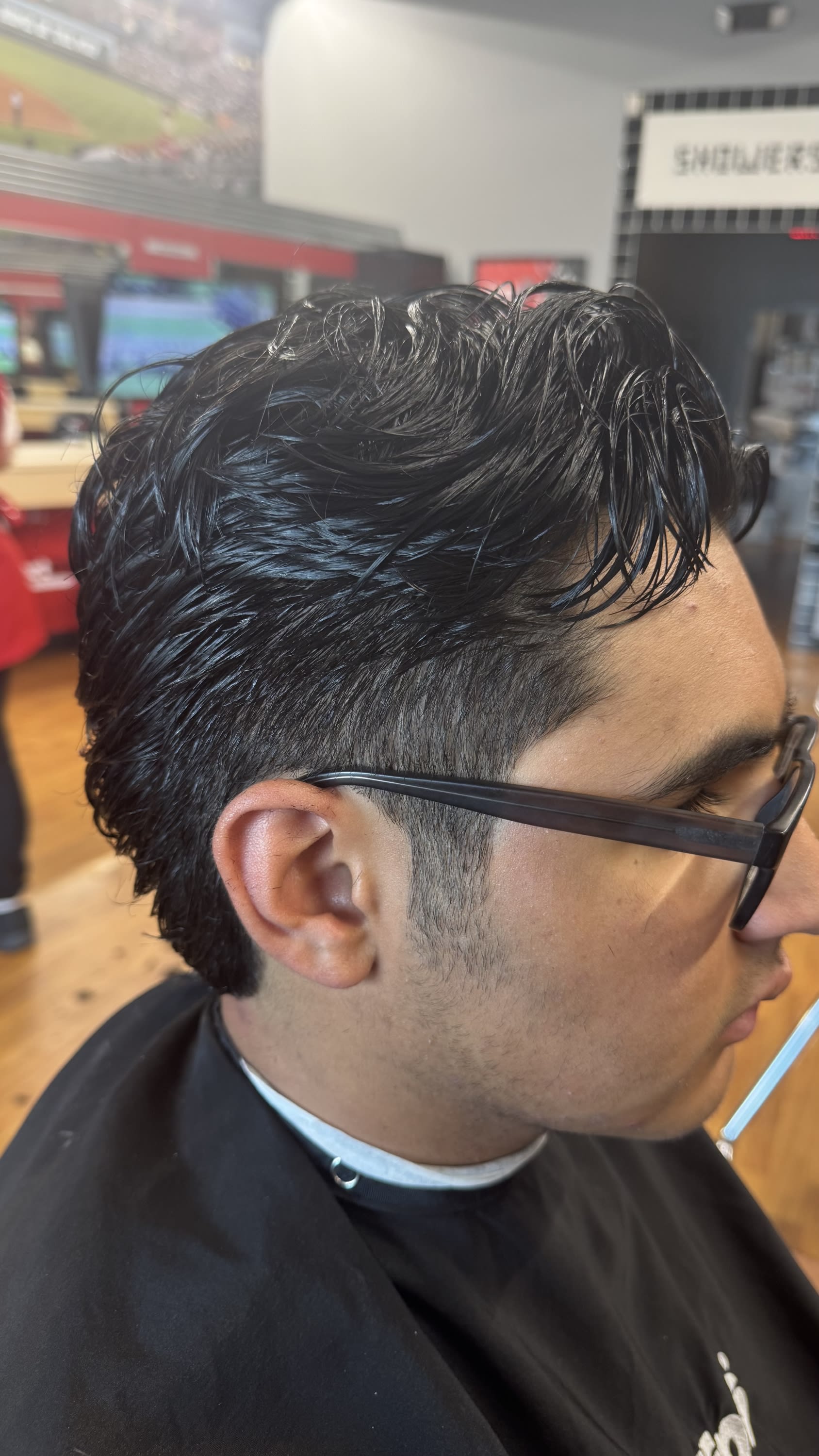 Modern mullet stylized cut with tapered sides and textured volume on top, executed by Jessica Cash at Sport Clips Haircuts in