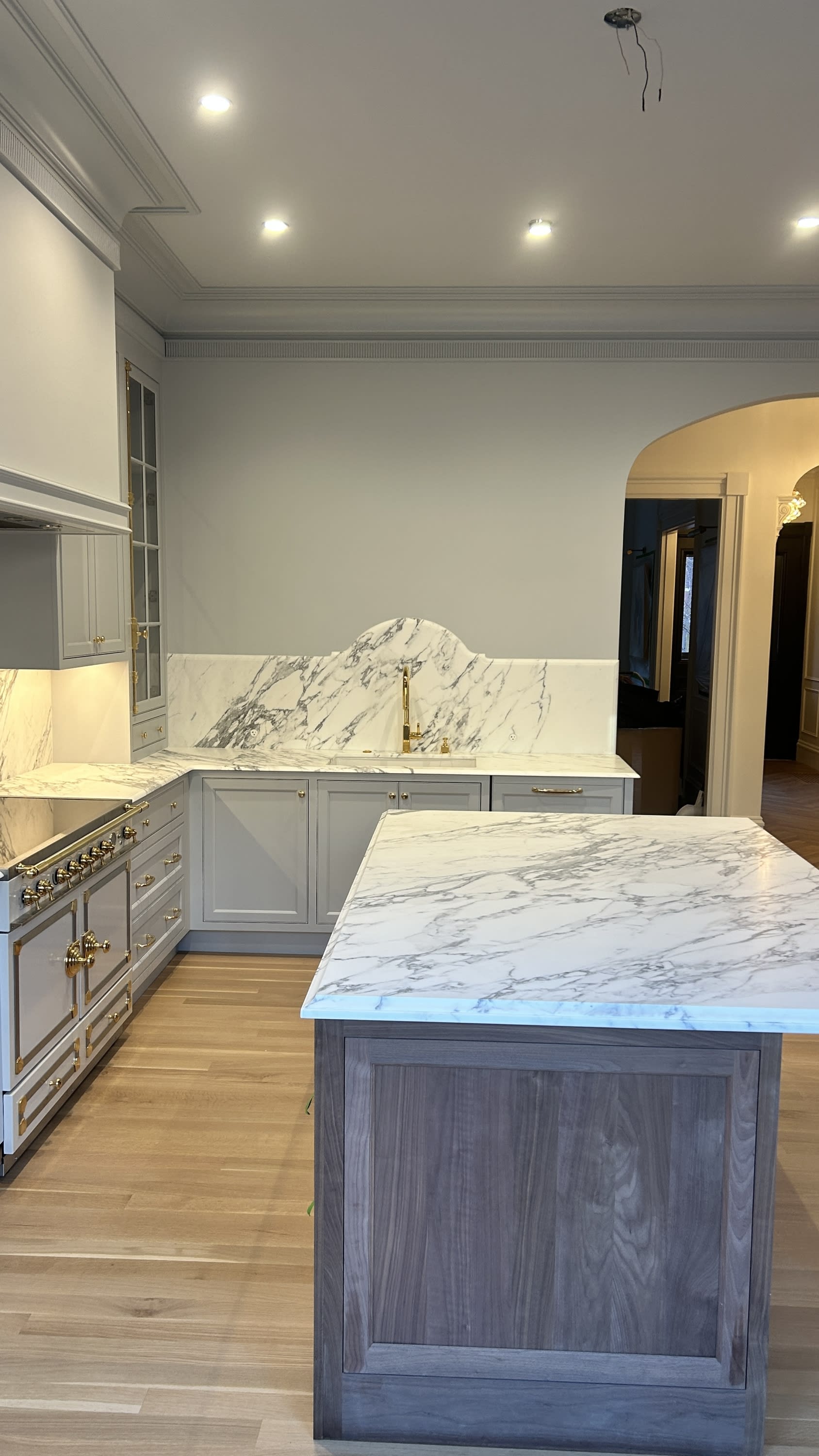 Custom kitchen with marble waterfall island, cabinetry, and premium finishes in Boston