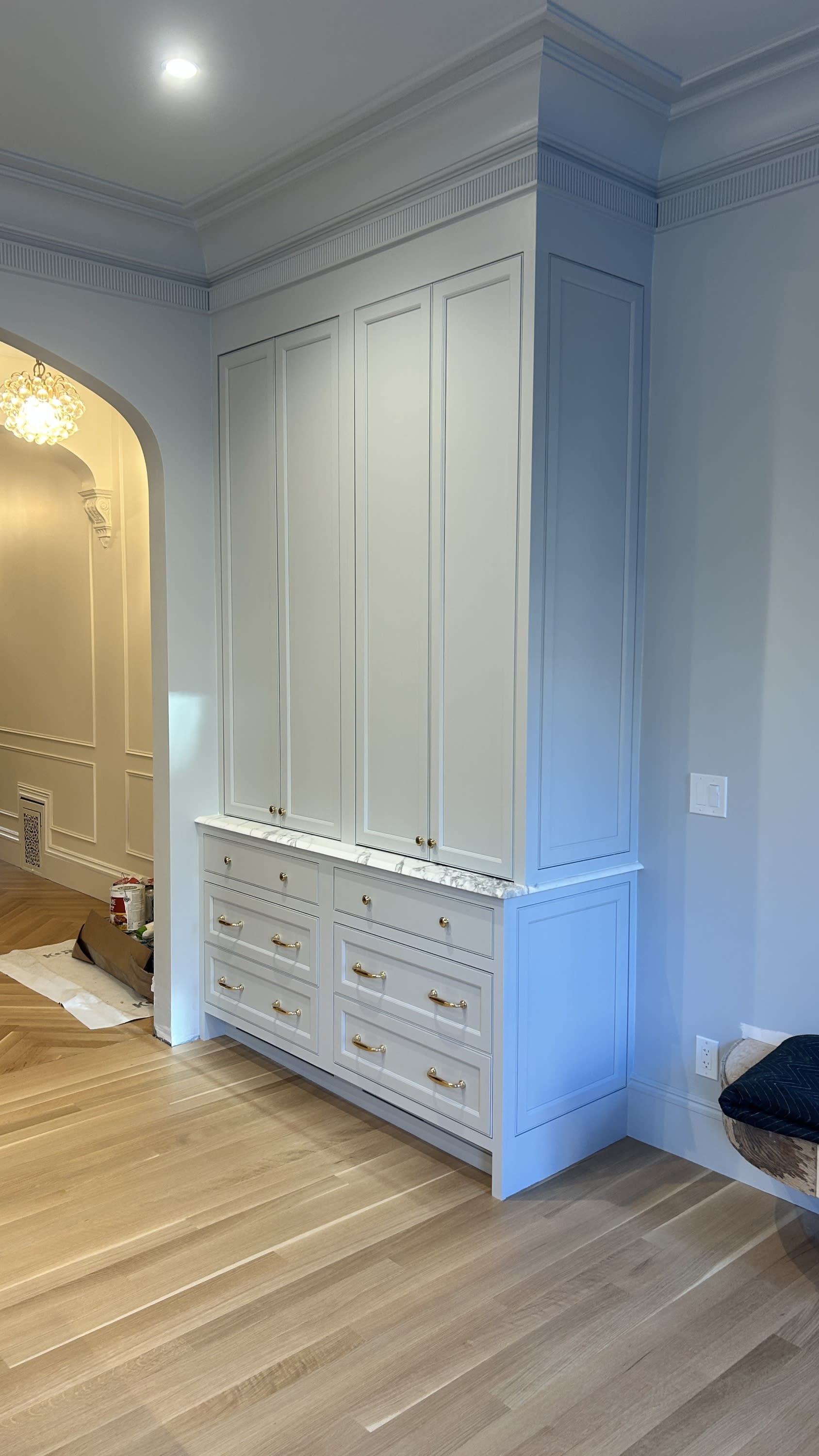 Custom built-in cabinetry with marble countertop and brass hardware in a remodeled kitchen