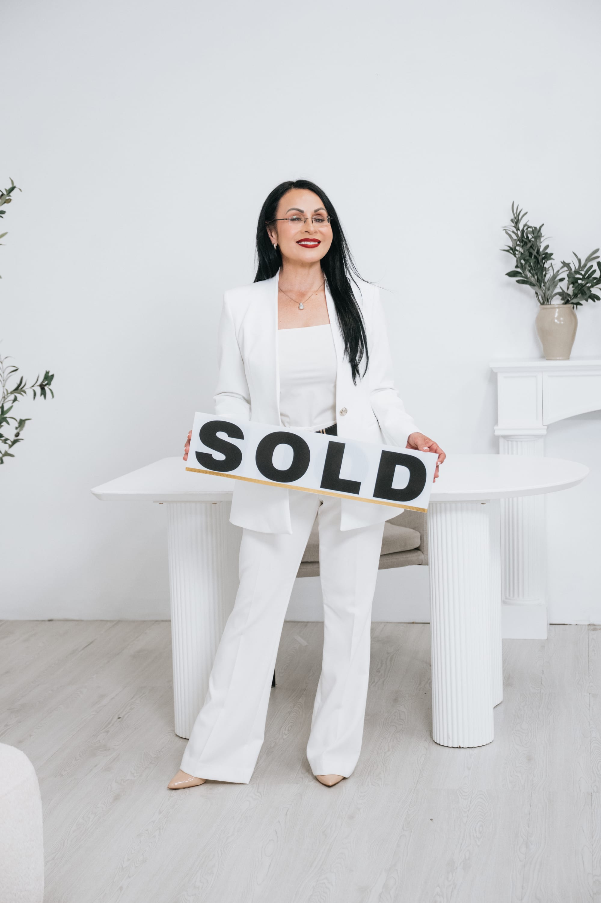 Realtor Flor Rodriguez, Broker and Owner of Synergy Home Realty, celebrating a successful home sale in Florida.