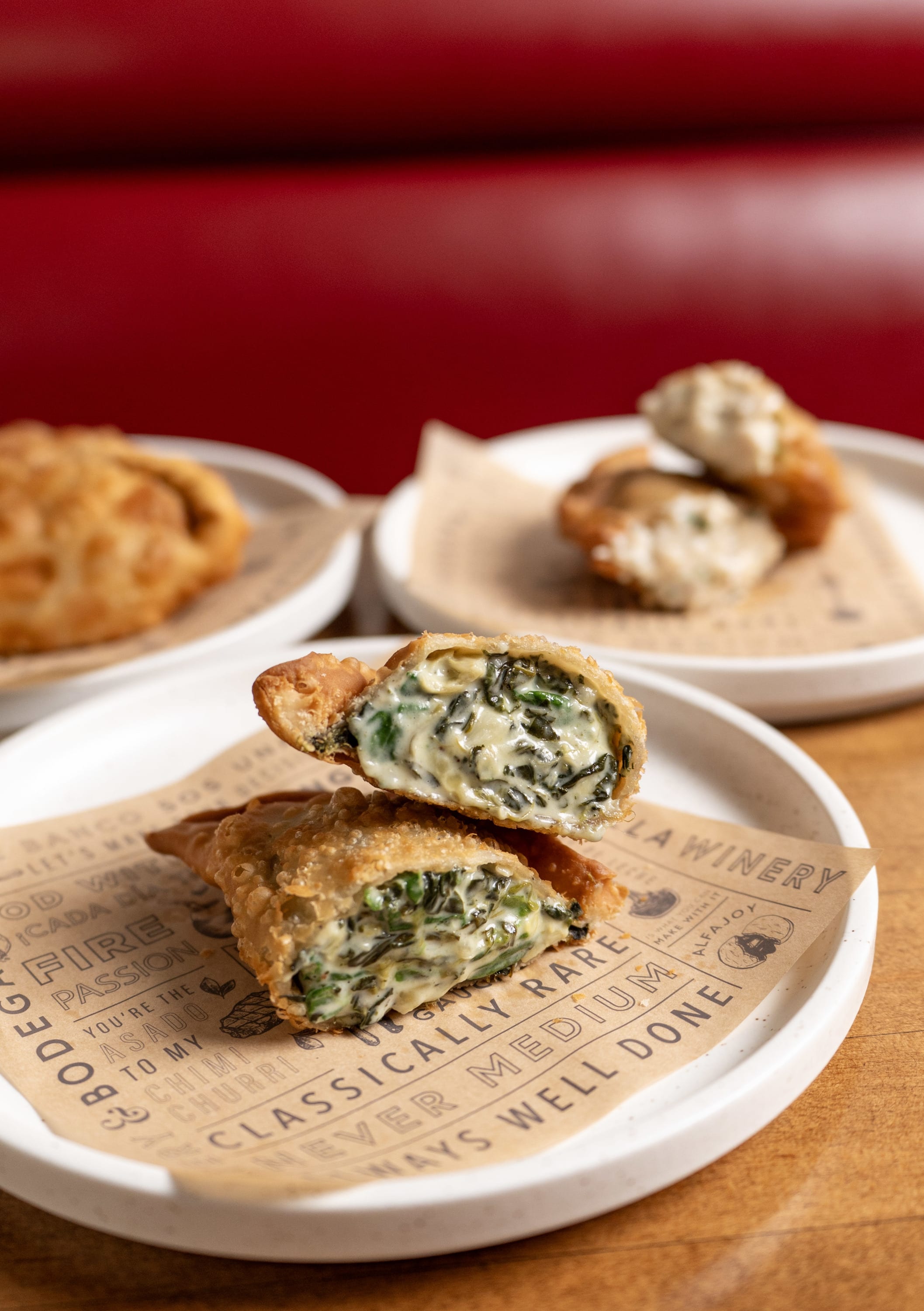 Table with three plates with empanadas open faced