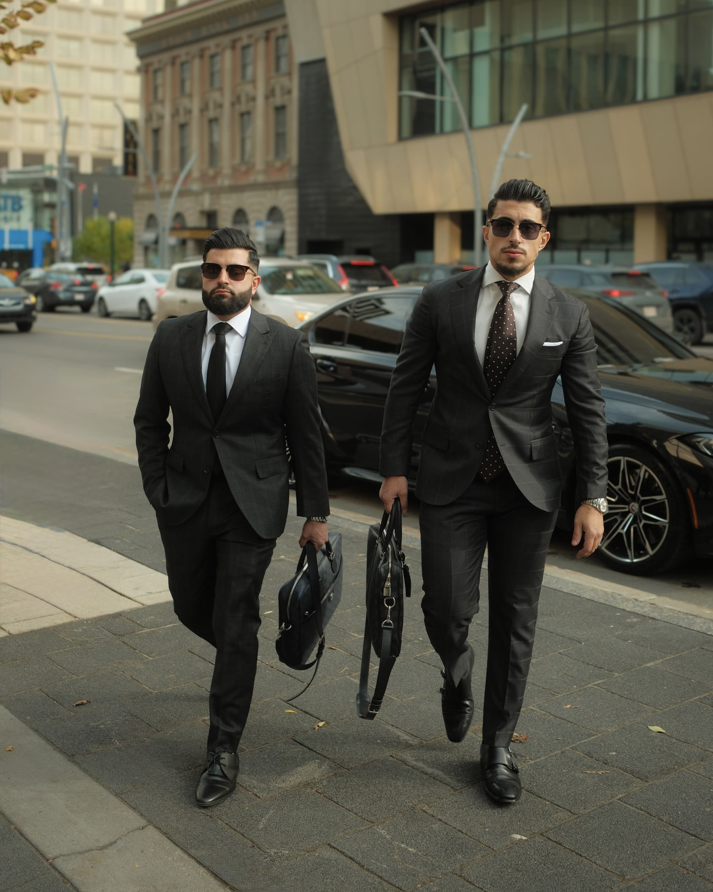 Edmonton Real Estate Lawyers "Berjak Law" dressed in black suits, holding briefcases and walking towards camera