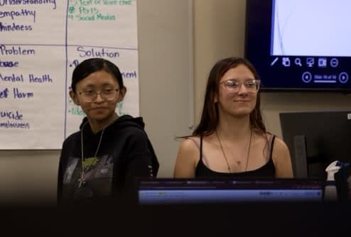 Two students presenting their AI project to the class.