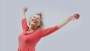 In this image, Nina Wise is in a candid and carefree pose smiling with her arms open.