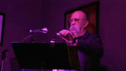 In this image, Raoul, Johnny's accompanist is playing the piano.  There is purple lghting in this scene to show the gloomines