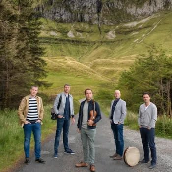 5 musicians surrounded by beautiful green hills