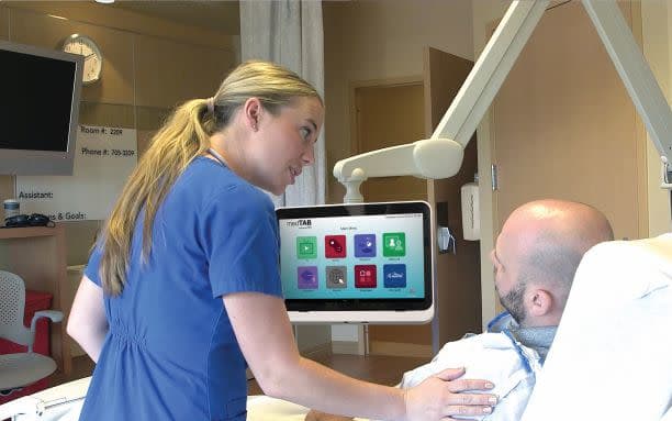 nurse at bedside with patient in bed using medTAB touchscreen tv by PDi