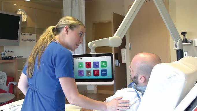 nurse w patient using medTAB TV in hospital bed