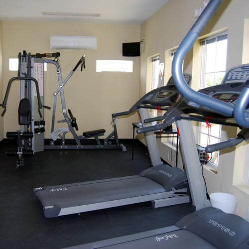 Community fitness center with treadmills, weight machines, and bright windows