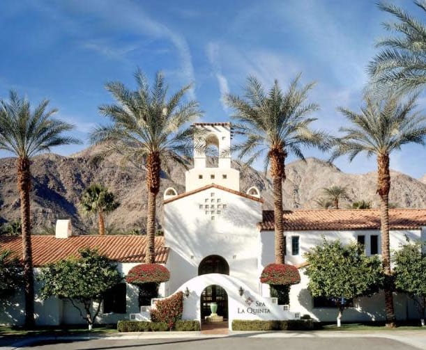 white building with palm trees and mountains