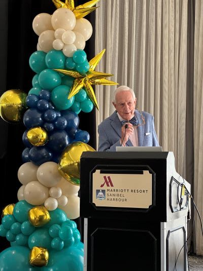 Al Hanser stands at podium and opens 2026 Shareholders' Meeting