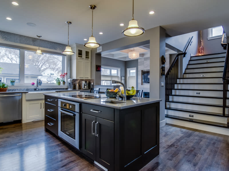 Luxury Nutana infill kitchen by Streetscape Homes featuring island with induction cooktop, built-in oven, and prep sink.