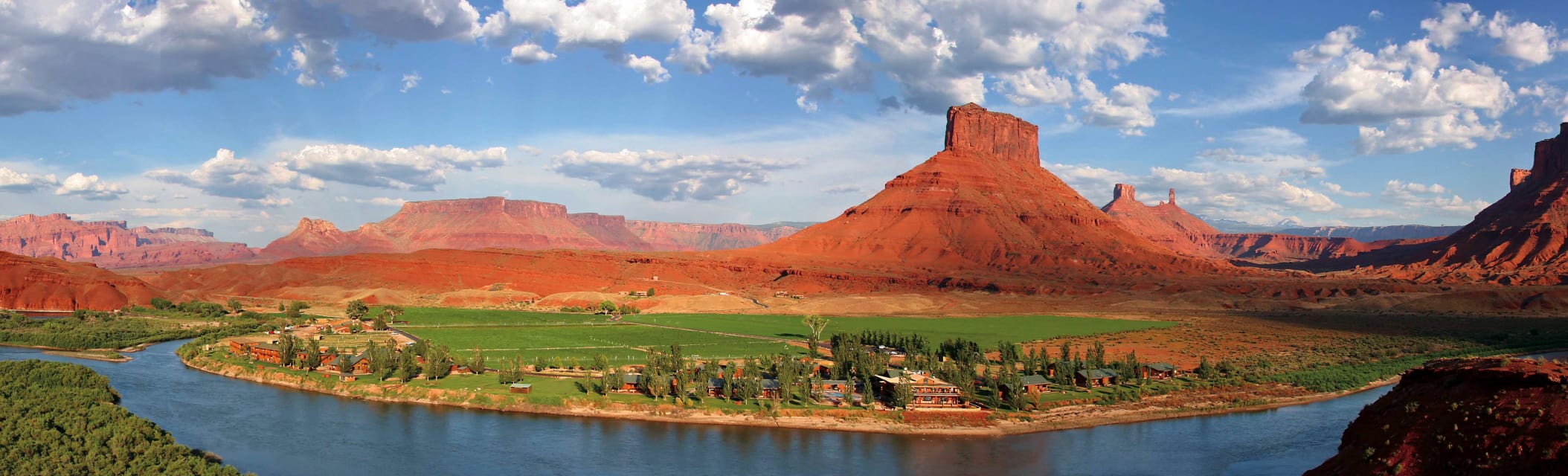 Panoramic aerial-style view of Sorrel River Ranch beside the Colorado River with dramatic red rock buttes and desert scenery