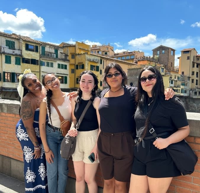 Five women posing for a photo on a bridge in Florence, Italy.
