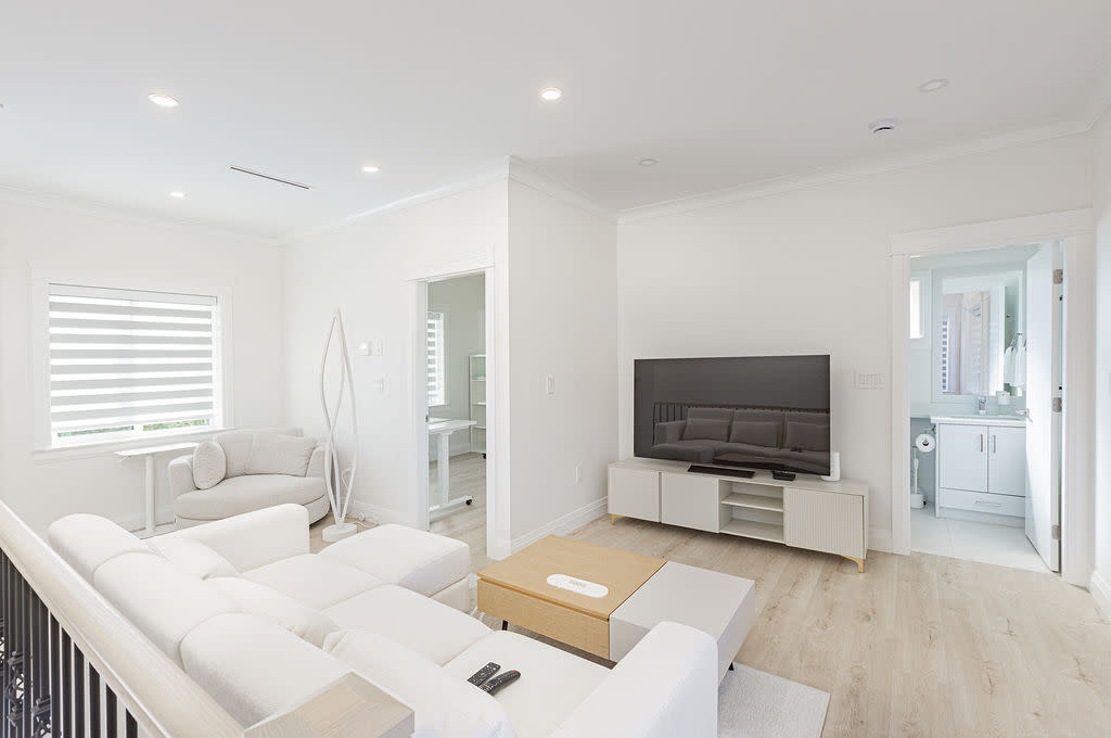 Bright living room at 6087 Neville laneway home featuring light wood flooring, white furnishings, modern finishes, large wind