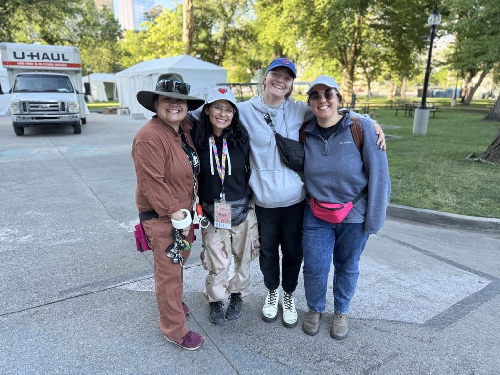Four smiling women team members on the festival grounds
