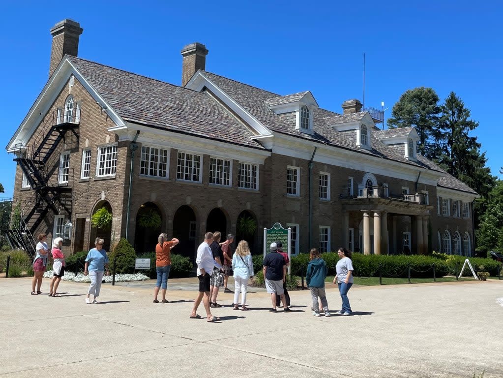 Visitors exploring the Felt Estate read the historic marker sign.