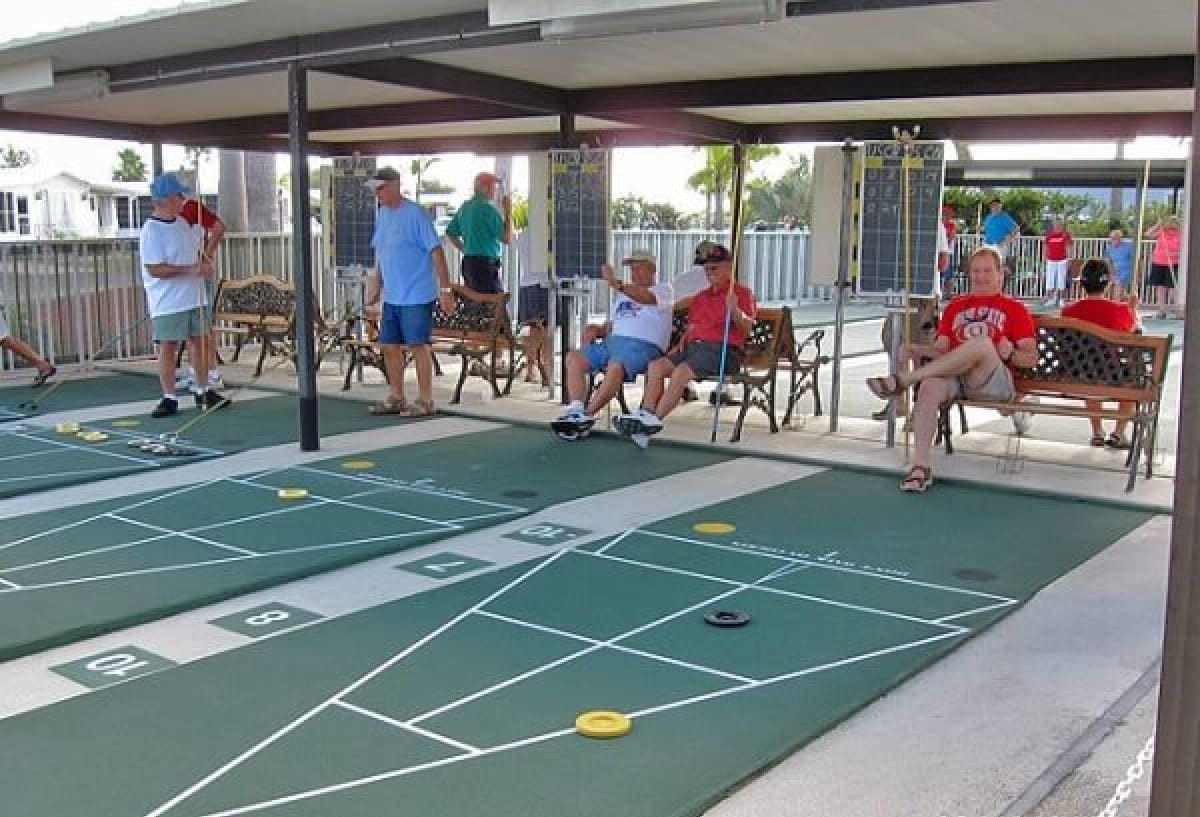 People gathering at covered shuffleboard courts at retirement community