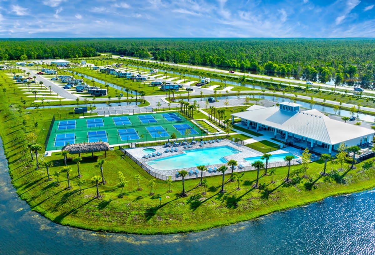 Aerial view of RV resort with pickleball courts, pool and lakeside waterfront