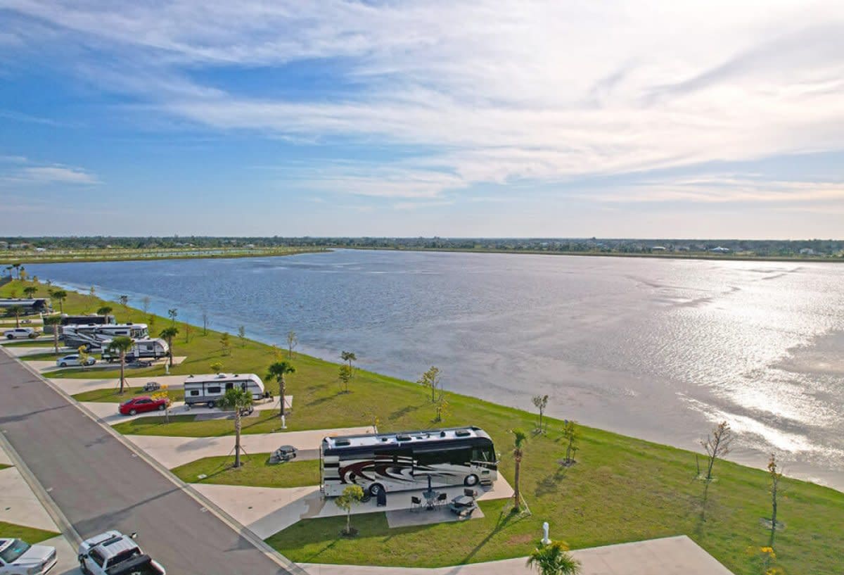 Large recreational vehicle parked on lakefront site with calm water view