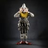 A dancer dressed as a clown with sad makeup and his hands spread out by his face