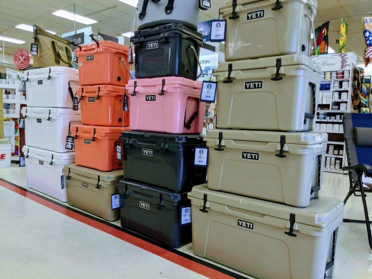 YETI coolers stacked in multiple colors on a store display.