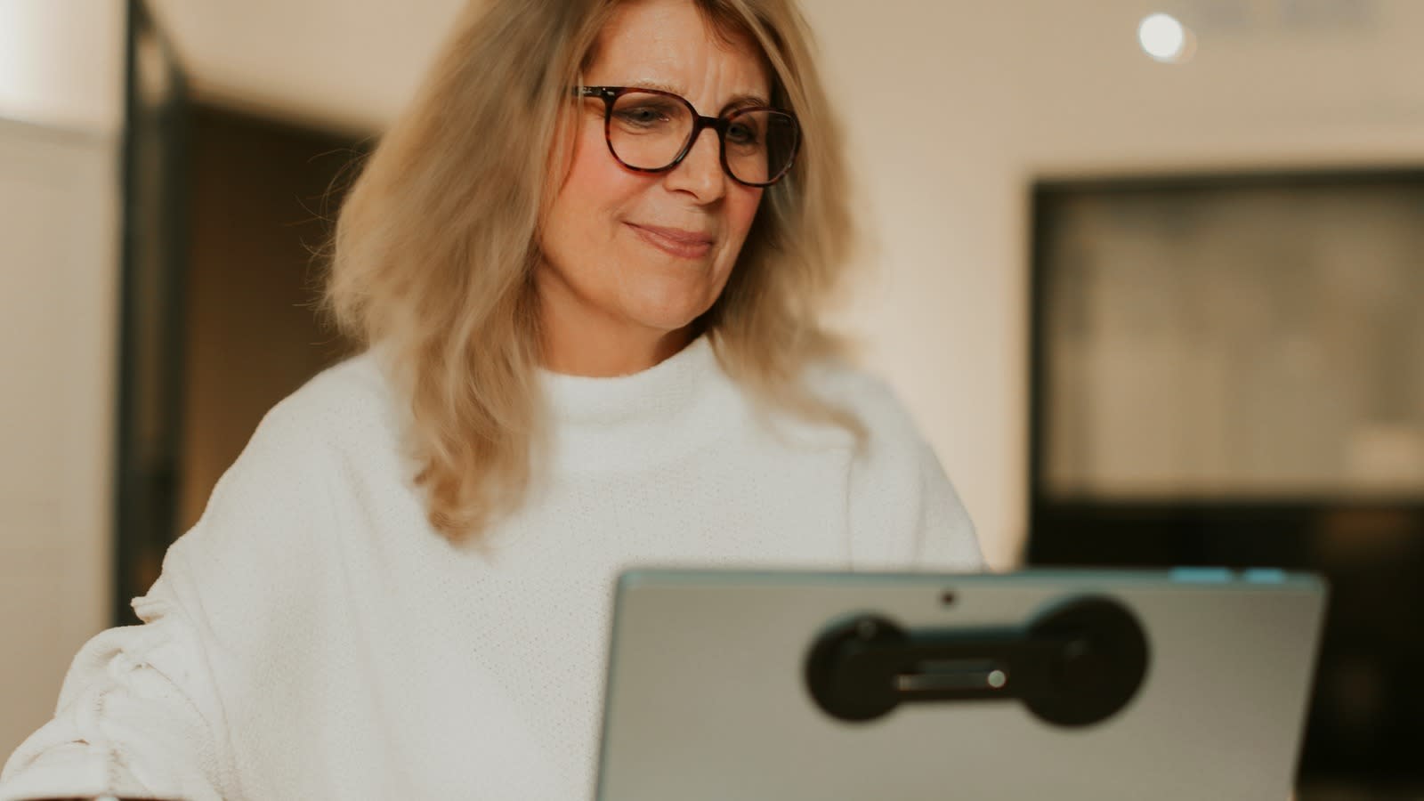 Laurie Carey Nebula Academy AI is YLaurie Carey, Founder & CEO of Nebula Academy, working at her laptop