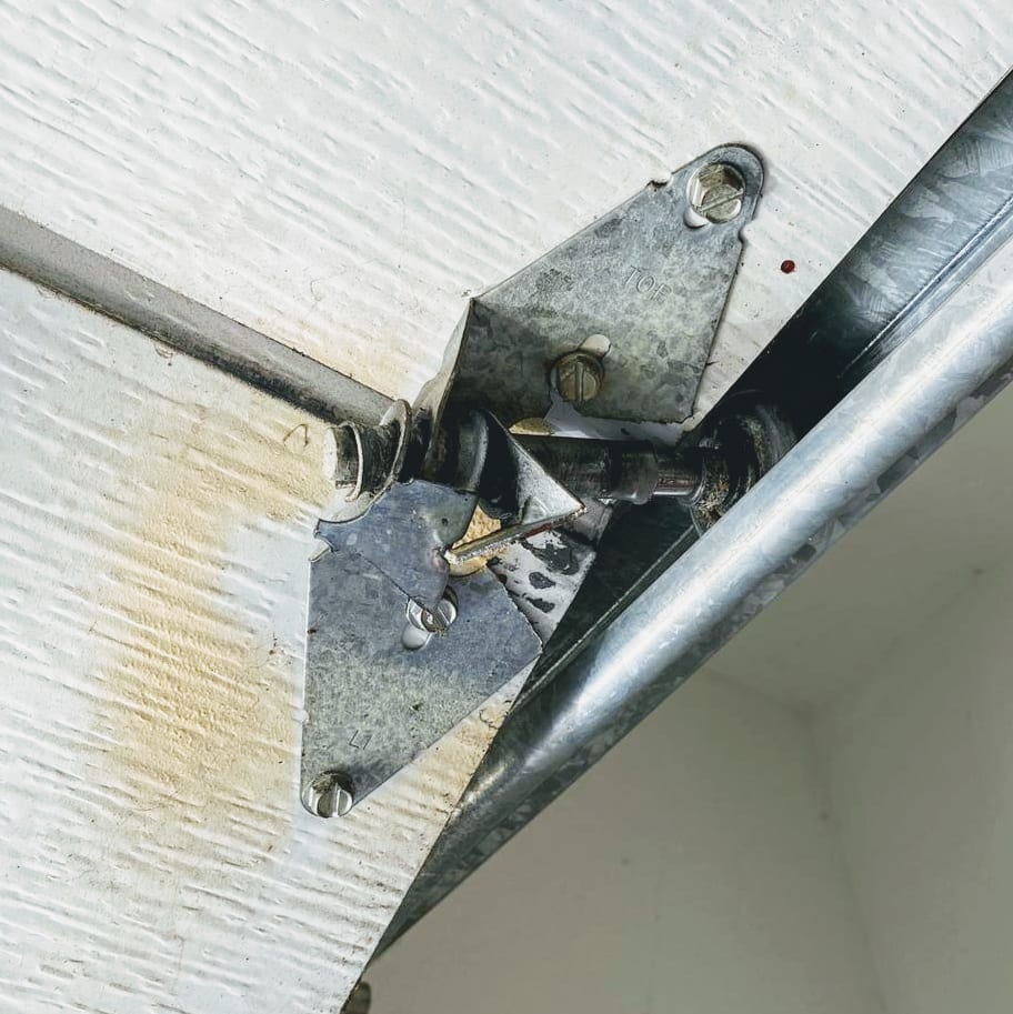 Close-up of a garage door roller and hinge assembly on the track