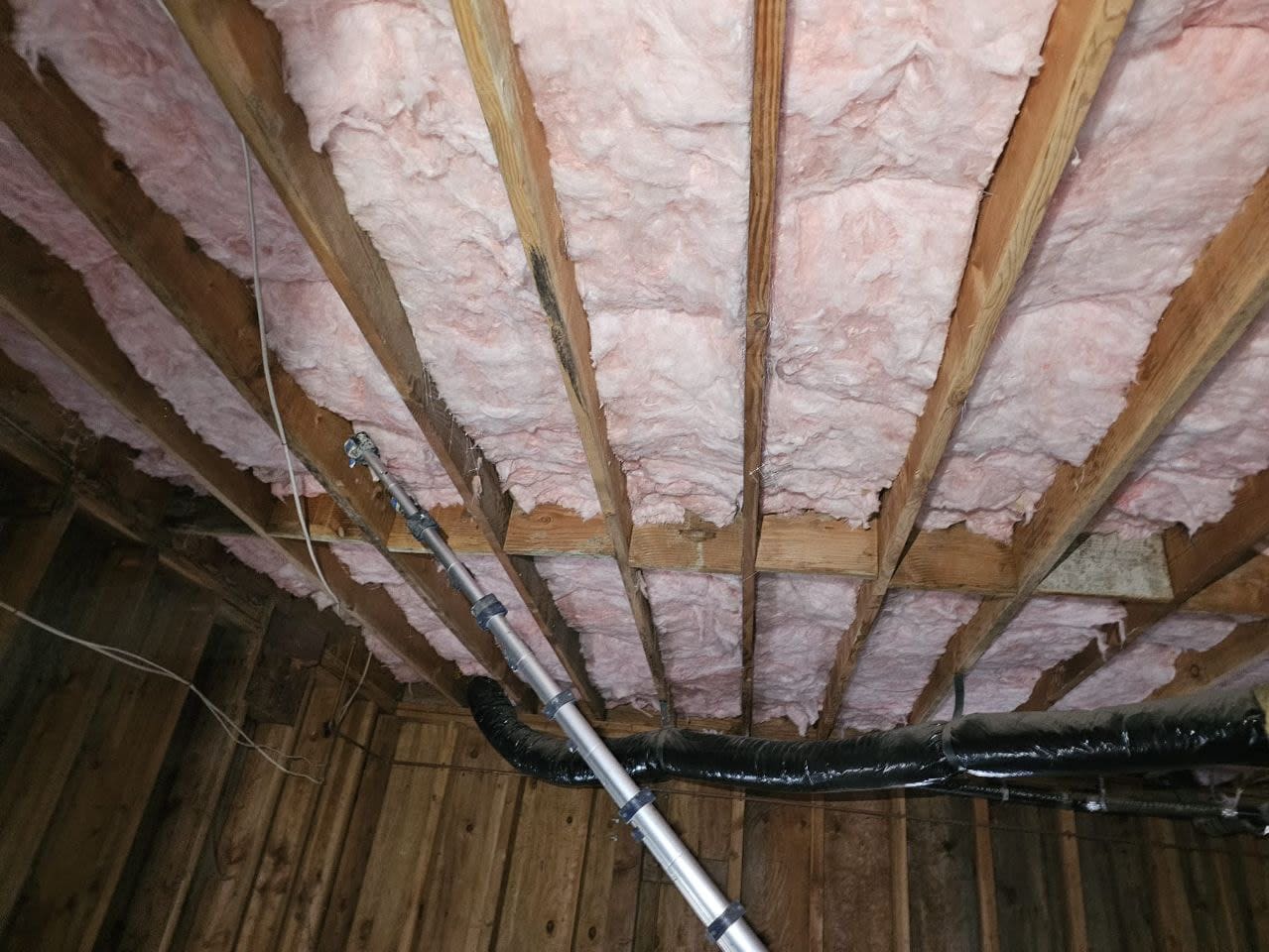 Installation of new fiberglass insulation along basement walls to improve temperature control and moisture resistance.