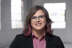 Corey has shoulder-length brown hair with dark fuchsia tips