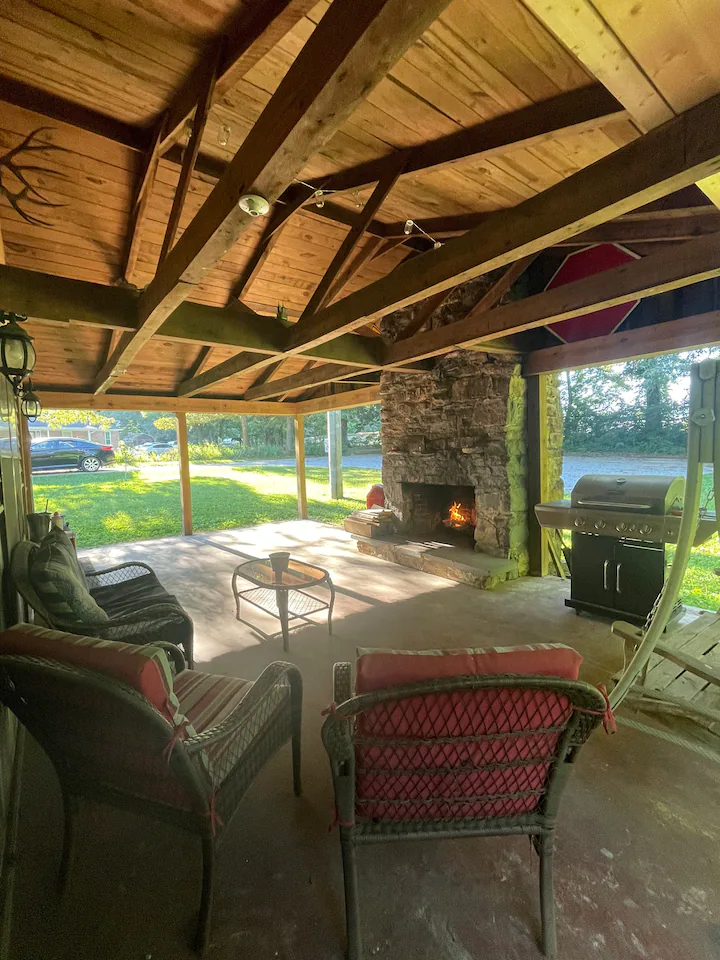 Patio with fireplace & grill. Notice there is a friendly neighbors house right across the driveway.