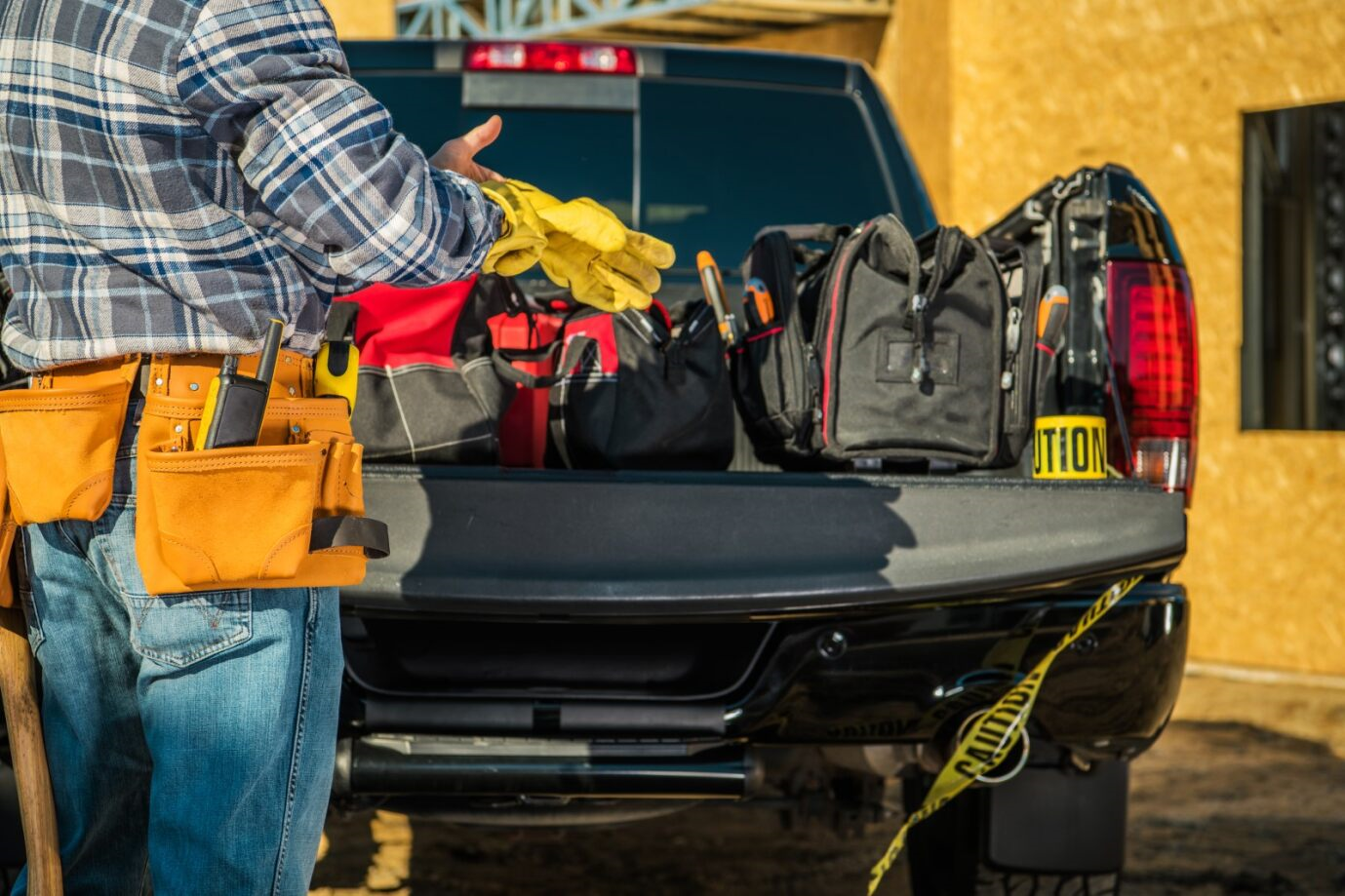 A person standing next to a truck with tools 
Description automatically generated