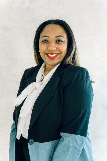 A person in a black suit  Description automatically generated